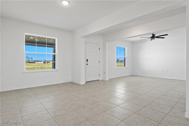 tiled spare room with ceiling fan and plenty of natural light