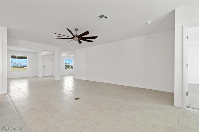 tiled empty room featuring ceiling fan