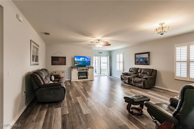 living room with a fireplace, wood-type flooring, and ceiling fan