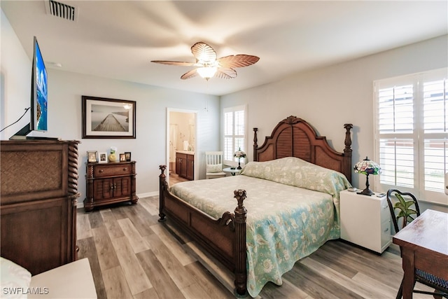 bedroom with ensuite bath, ceiling fan, and light hardwood / wood-style flooring