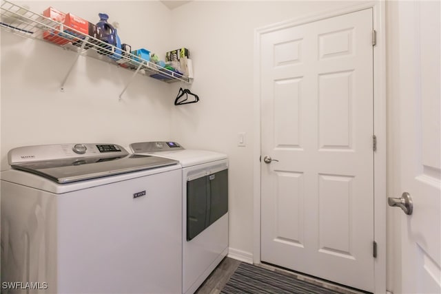 clothes washing area with washing machine and dryer and dark wood-type flooring