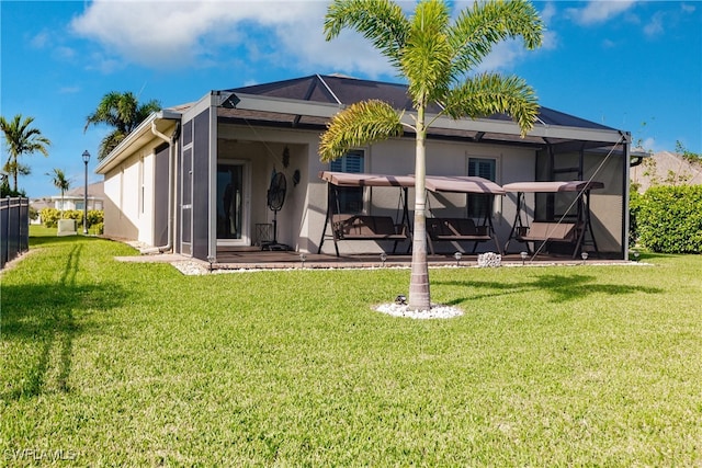 rear view of property featuring a lanai, a patio, and a yard