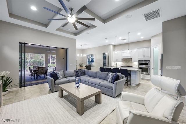 living room featuring coffered ceiling, ceiling fan with notable chandelier, and beamed ceiling