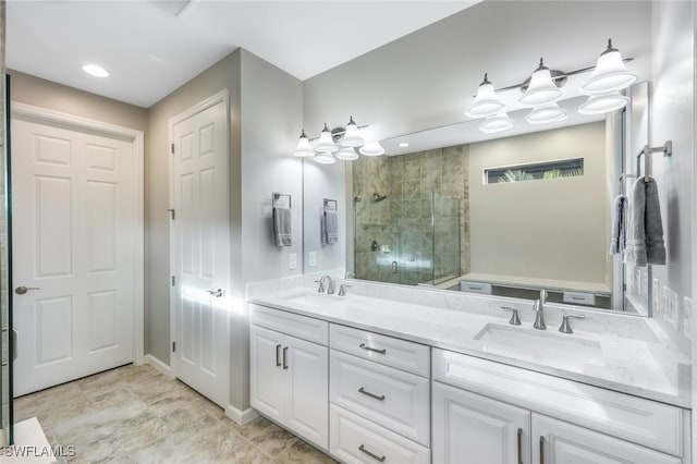 full bathroom featuring a sink, a shower stall, baseboards, and double vanity