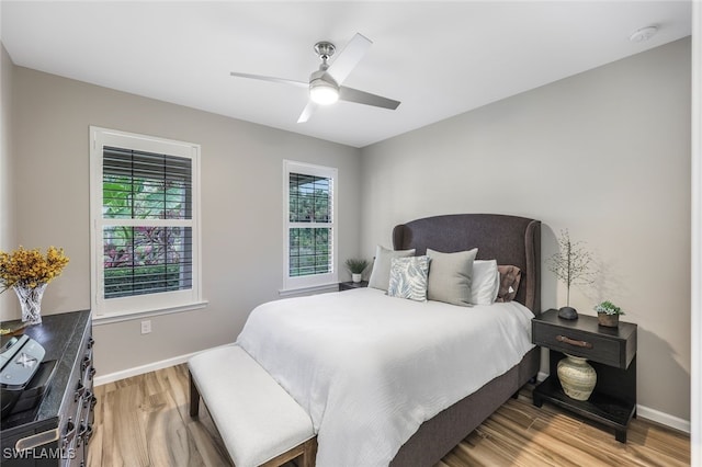 bedroom with ceiling fan, baseboards, and wood finished floors