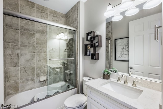 full bathroom featuring vanity, shower / bath combination with glass door, and toilet