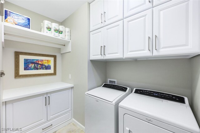 washroom with cabinets, separate washer and dryer, and light tile patterned floors