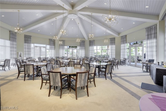 dining room featuring beamed ceiling, a towering ceiling, light colored carpet, and an inviting chandelier