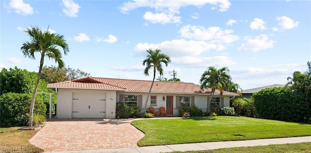 ranch-style house with a garage and a front lawn