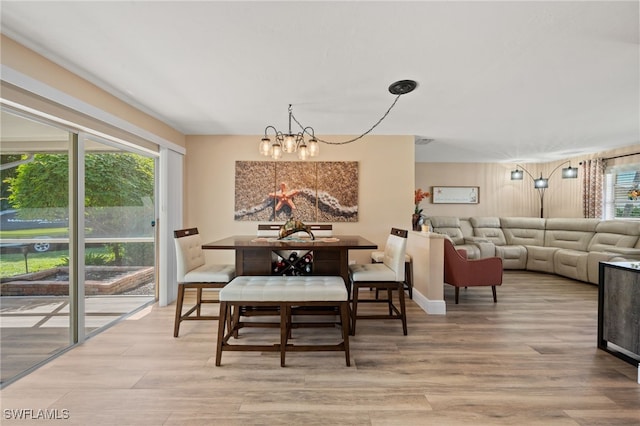 dining room with light hardwood / wood-style flooring and a chandelier