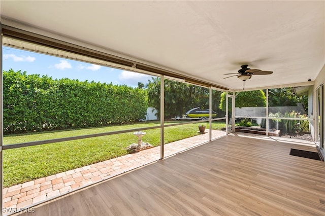 unfurnished sunroom with ceiling fan