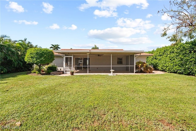 back of house featuring a lawn, ceiling fan, a sunroom, and a patio area