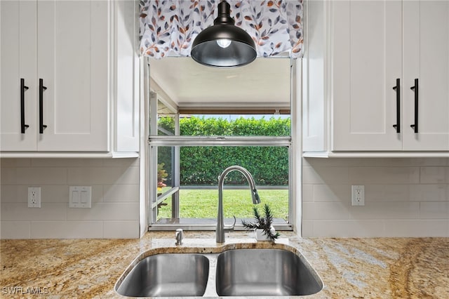 kitchen with a healthy amount of sunlight, sink, and light stone counters