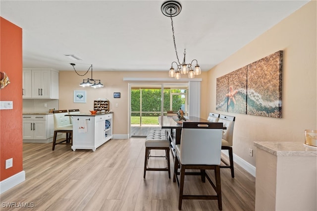 dining room with a notable chandelier and light hardwood / wood-style flooring