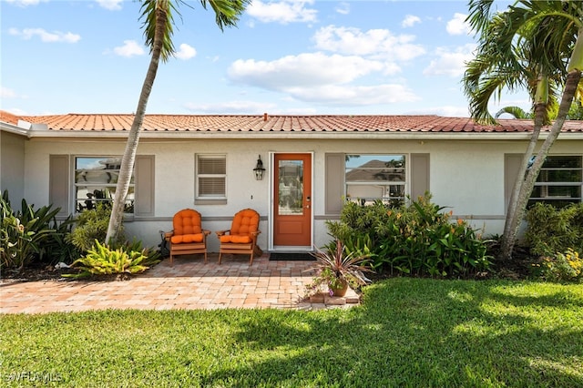 rear view of property with a lawn and a patio area