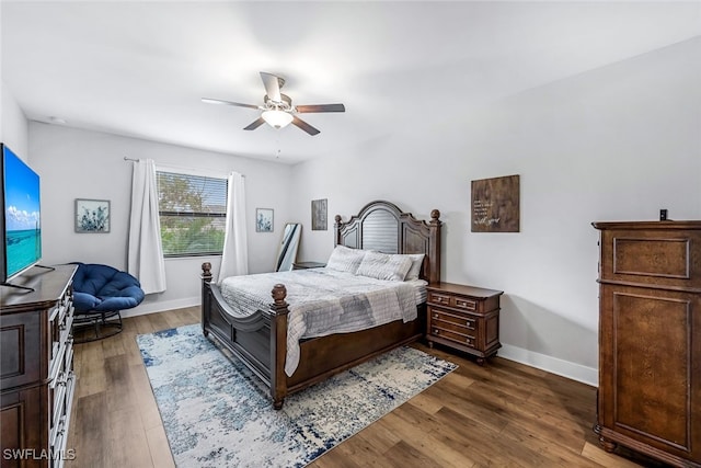 bedroom with dark hardwood / wood-style floors and ceiling fan