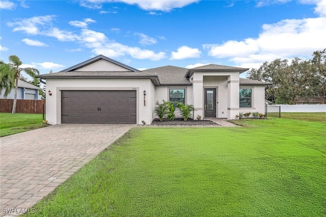 view of front of home with a front yard and a garage