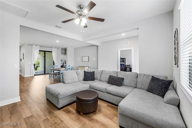 living room with wood-type flooring and ceiling fan