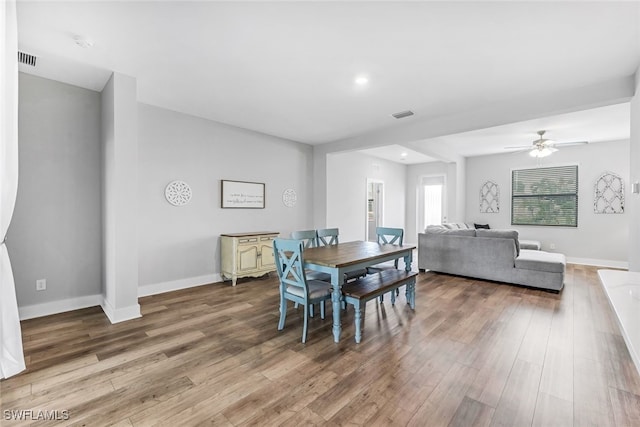 dining area with wood-type flooring and ceiling fan