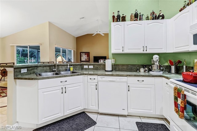 kitchen with lofted ceiling, white cabinets, kitchen peninsula, sink, and white appliances