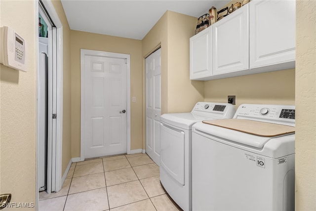 laundry room featuring cabinets, washer and dryer, and light tile patterned flooring