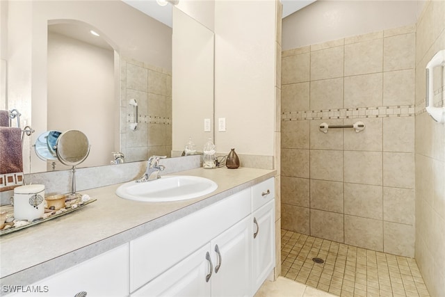 bathroom with vanity, a tile shower, and tile patterned floors