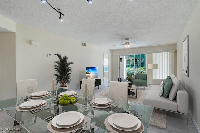 dining area featuring a textured ceiling, track lighting, and ceiling fan