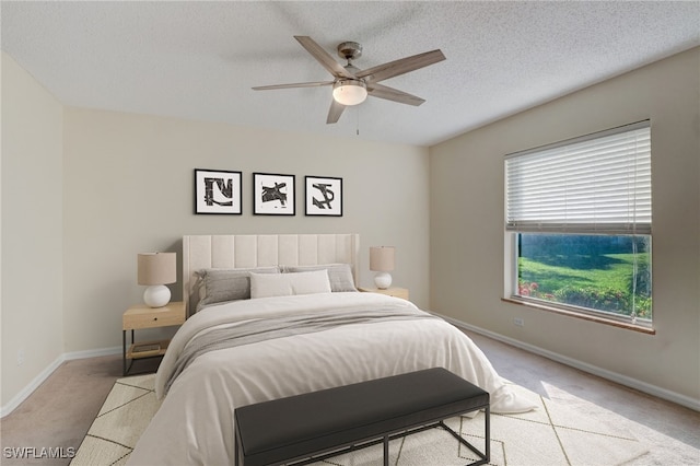 carpeted bedroom with ceiling fan and a textured ceiling