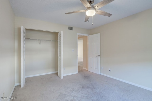 unfurnished bedroom featuring light carpet, a closet, and ceiling fan