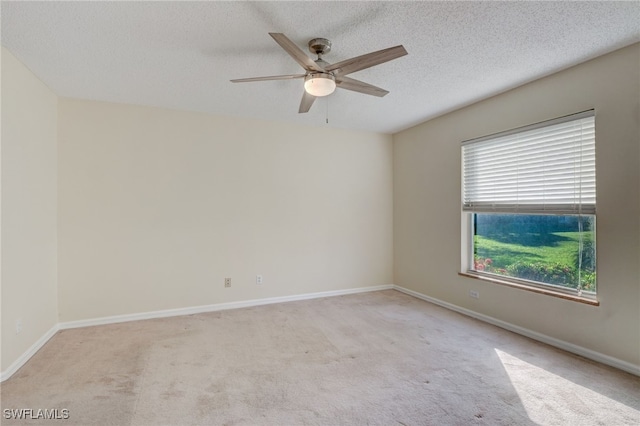 unfurnished room featuring a wealth of natural light, light colored carpet, and ceiling fan