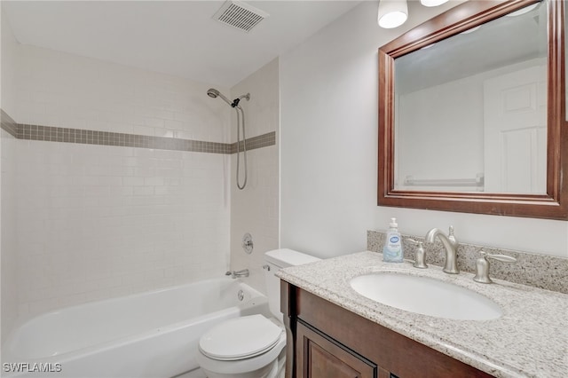 full bathroom featuring vanity, tiled shower / bath combo, and toilet