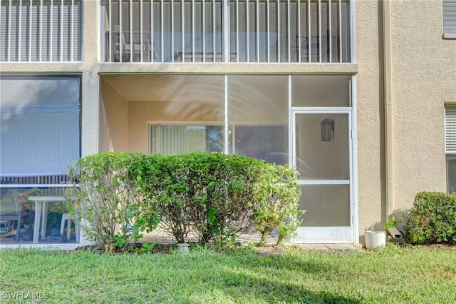 view of home's exterior featuring a balcony and a lawn