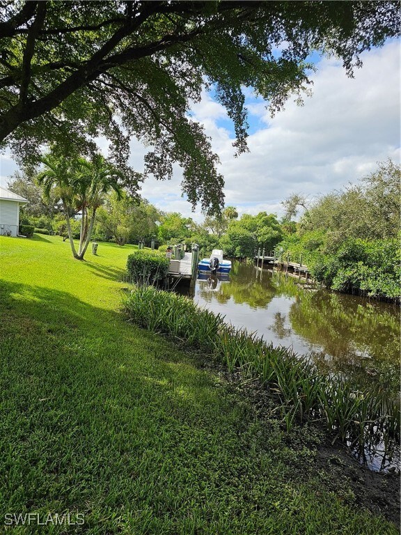 view of yard featuring a water view and a dock