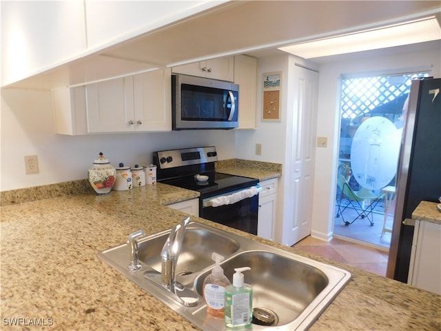 kitchen with white cabinetry, stainless steel appliances, sink, and light stone counters