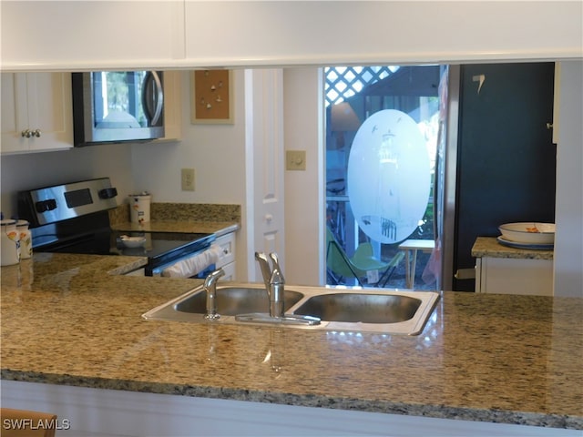 kitchen featuring appliances with stainless steel finishes, sink, and white cabinets