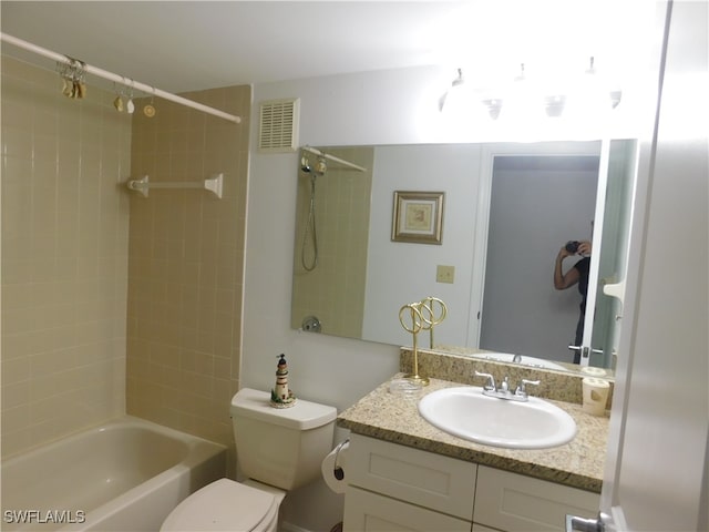 full bathroom with vanity, tiled shower / bath combo, and toilet