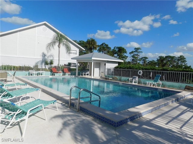 view of swimming pool with an outdoor structure and a patio area