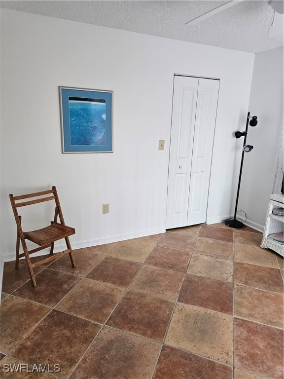 interior space with a closet, a textured ceiling, and ceiling fan