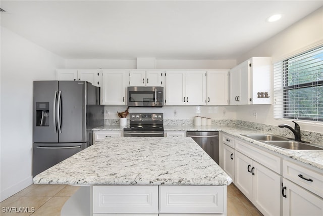 kitchen featuring sink, appliances with stainless steel finishes, a kitchen island, and white cabinets