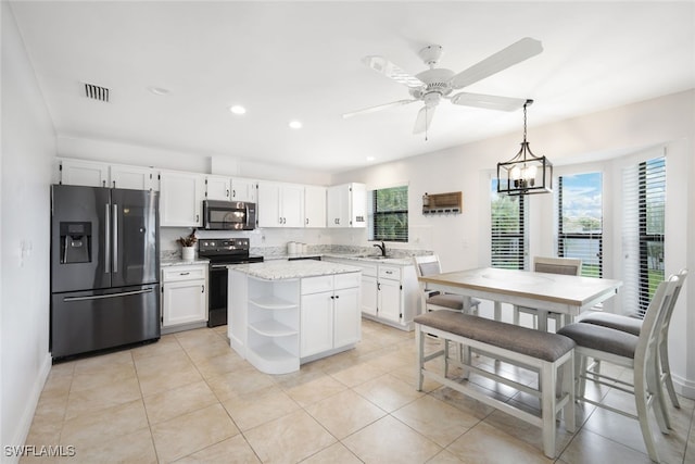 kitchen with white cabinets, hanging light fixtures, a kitchen island, sink, and stainless steel appliances