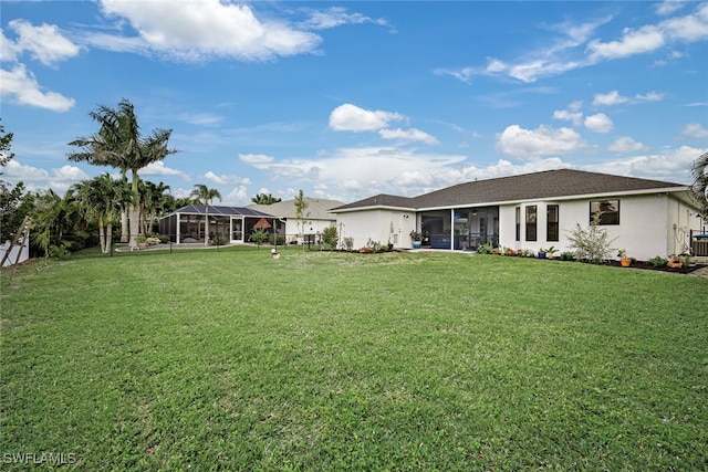 view of yard featuring glass enclosure and a sunroom