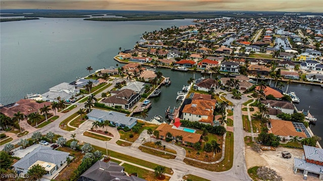 aerial view at dusk featuring a water view