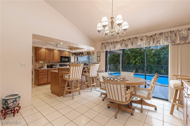 tiled dining space with ceiling fan with notable chandelier and high vaulted ceiling