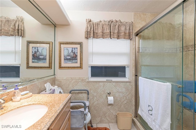 bathroom with vanity, tile patterned floors, walk in shower, and tile walls