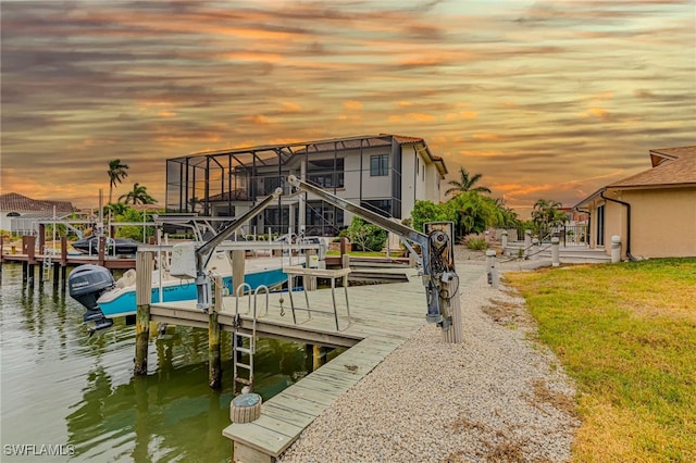 dock area with a water view and a lawn