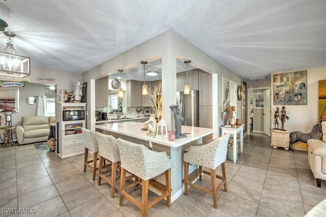 tiled dining room with an inviting chandelier and a textured ceiling