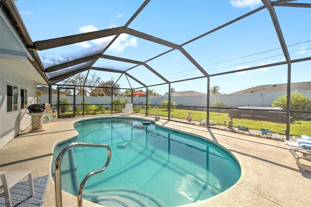 view of swimming pool featuring a lawn, a lanai, and a patio