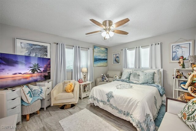 bedroom with ceiling fan, multiple windows, and a textured ceiling