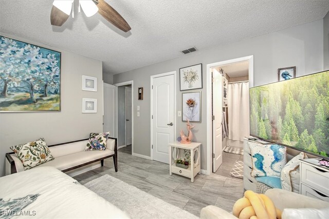 living room with ceiling fan and a textured ceiling