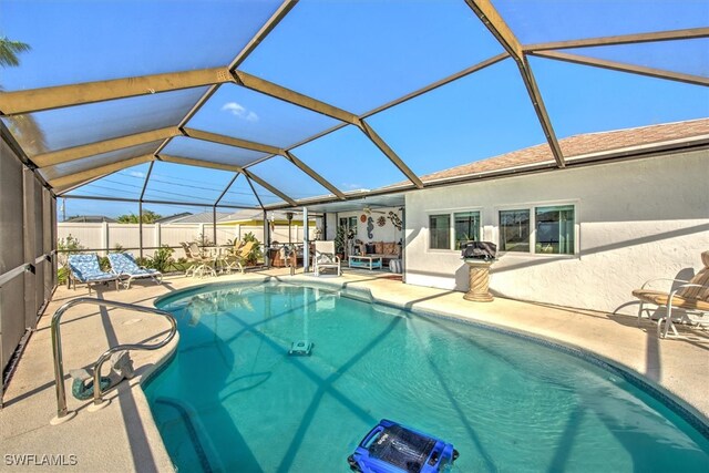 view of swimming pool featuring a patio area and a lanai